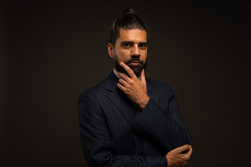 A beautiful shot of a Hispanic man showing emotions in front of a black background