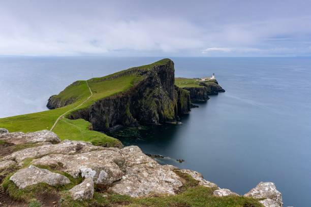 istock Big cliff with a lighthouse on it surrounded by the ocean on a cloudy day 1453262745