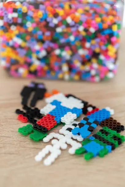 A vertical shot of colorful legos on a wooden table in a blurred background
