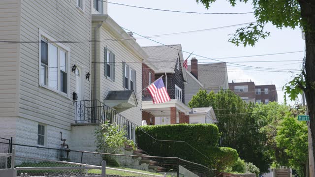 4K American flag waving in front of homes in the Bronx. New York, United States