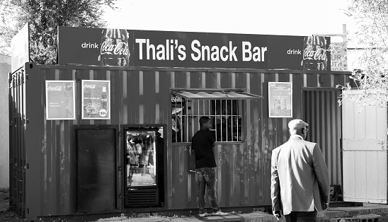 Johannesburg, South Africa – September 06, 2022: A grayscale shot of people near a small kiosk