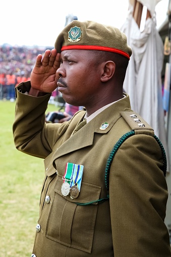 Dark-skinned soldier in hat facing national flag series - Jordan