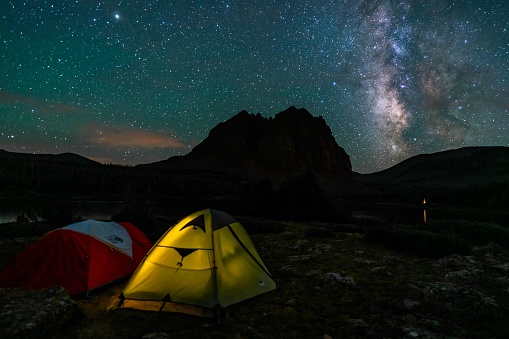 A closeup of tents on a Milky way sky and the Uinta Mountains background