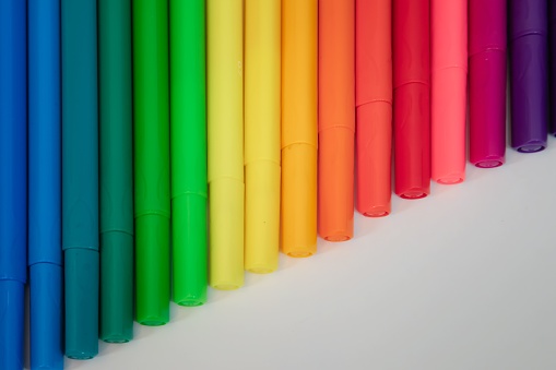 Colorful pens stacked sequentially on a white surface. Great for backgrounds