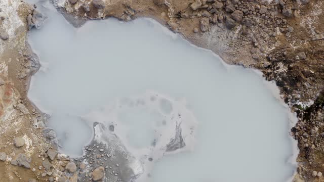 Aerial overview shot of hot geothermal mud pot in Iceland
