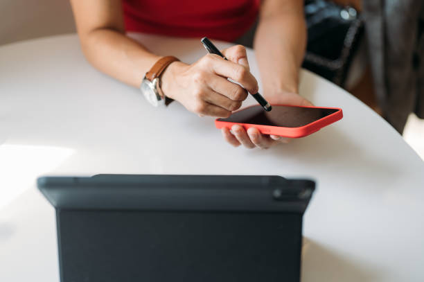 istock Close up of woman hands using digitized pen writing on smart phone in the office 1453276411