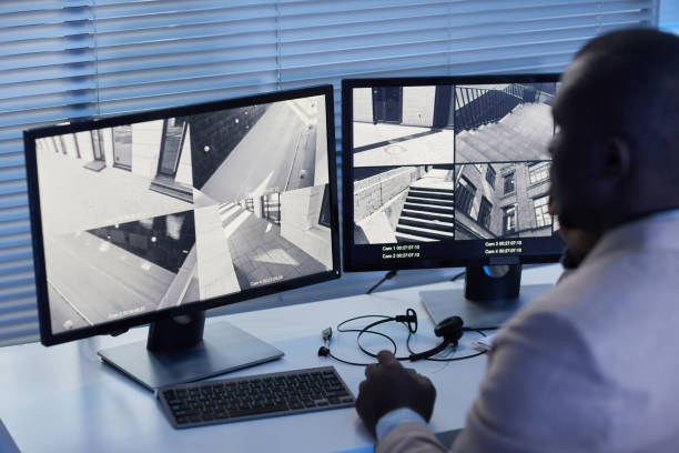 istock Black man looking at surveillance camera footage in security center 1453276508