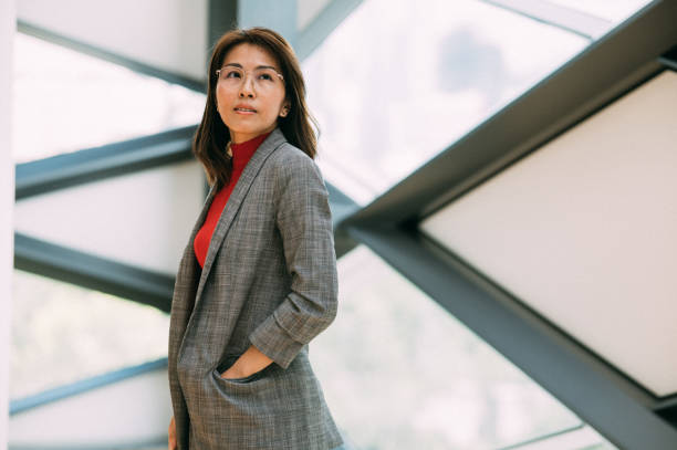 Shot of a confident Asian businesswoman working in a modern office. Looking away camera stock photo