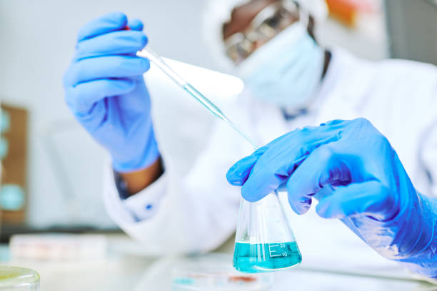 istock Black scientist taking liquid samples with pipette in laboratory 1453276909