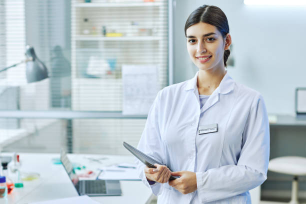 istock Smiling Middle Eastern woman standing in laboratory 1453277439
