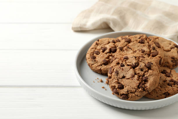 istock Delicious chocolate chip cookies on white wooden table. Space for text 1453277710