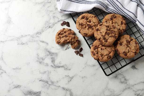 istock Delicious chocolate chip cookies on white marble table, flat lay. Space for text 1453277739