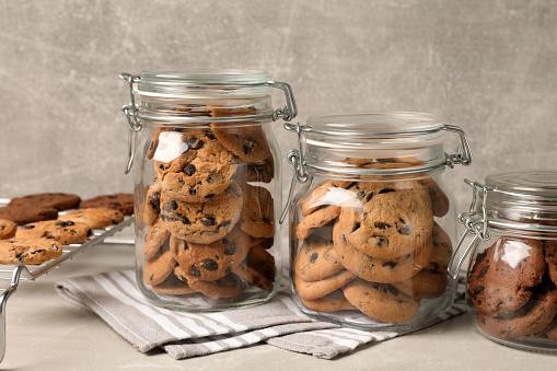 Jars of chocolate chip cookies on light grey table