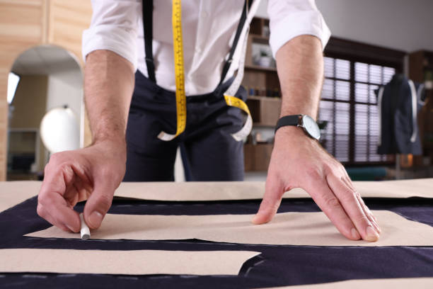 istock Professional tailor marking sewing pattern on fabric with chalk at table in workshop, closeup 1453279007