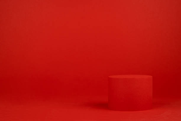 istock Red festive Christmas stage with one cylinder podium mockup on table for presentation cosmetic products, gifts, goods in simple modern minimalist style, copy space. Template for advertising, design. 1453279177