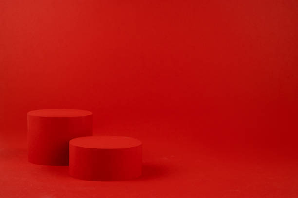 istock Luxury bright red scene - two cylinder podiums mockup on table for presentation cosmetic products, gifts, goods in fashion trendy modern style, copy space. Template for advertising, design. 1453279182