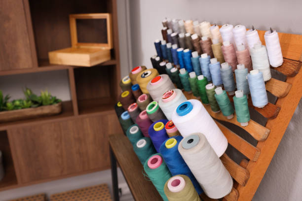 istock Set of colorful threads on stand in tailor studio. Space for text 1453279214