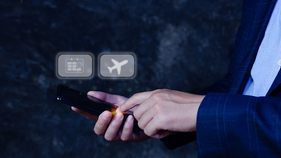 Businessman touching smartphone to select flight by pressing touch screen airplane button,Business Airplane transportation concept