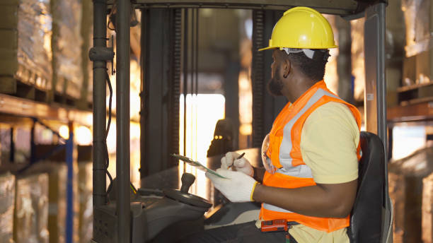 Portrait of black man worker working in large warehouse retail store industry factory. Rack of stock storage. Cargo in ecommerce and logistic concept. Depot. People lifestyle. Shipment service. retrato de un trabajador negro que trabaja en una gran fábrica de almacenes de la industria de tiendas minoristas. rack de almacenamiento en stock. carga en concepto de ecommerce y logística. depósito. estilo de vida de las personas. servicio de envío.