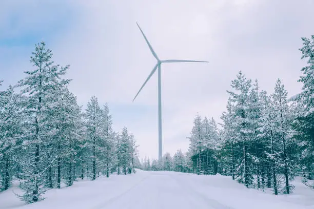 Photo of Aerial view Wind turbine in snow winter landscape in Finland. Alternative energy in winter.