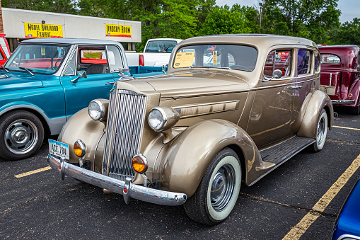 Iola, WI - July 07, 2022: High perspective front corner view of a 1937 Packard 115 Touring Sedan at a local car show.