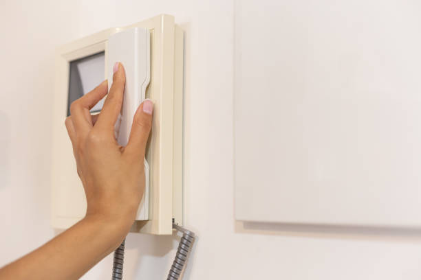 istock Close-up of a young woman's hand picking up intercom at home 1453290757