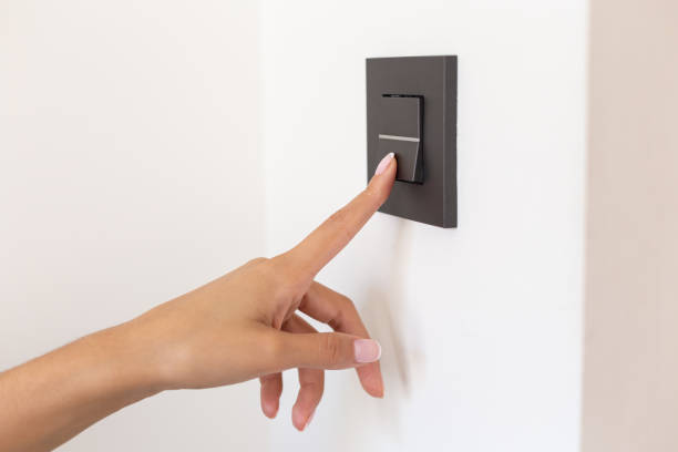 istock Close up of young woman's hand pressing the light switch button 1453291864