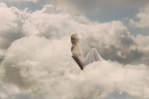 woman rests peacefully sitting inside a cloud, concept of relaxation, dreams, well-being and freedom