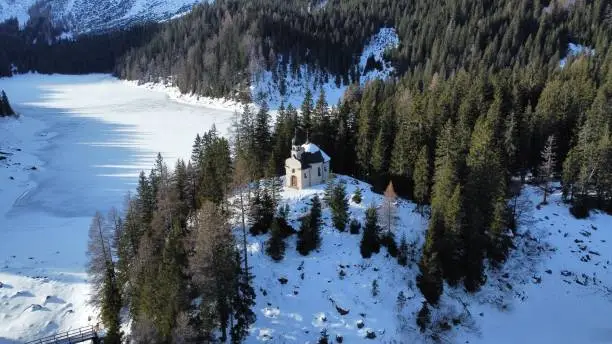 Chapel with snow in the middle of a frozen lake.