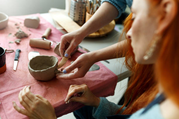istock Pottery workshop class. A pottery crafts dish from a raw clay. Creating ceramics 1453302869