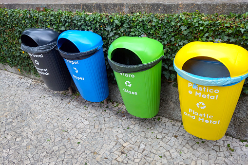 Selective garbage (paper, plastic, metal and glass, from left to right), written in portuguese