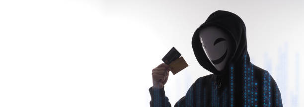 istock Hacker man and credit cards in hand. Represent credit cards personal data stolen by anonymous man in Black hood shirt. Credit cards data security and Cyber crime digital. Money transection unsecured. 1453306119