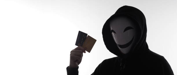 istock Hacker man and credit cards in hand. Represent credit cards personal data stolen by anonymous man in Black hood shirt. Credit cards data security and Cyber crime digital. Money transection unsecured. 1453306140