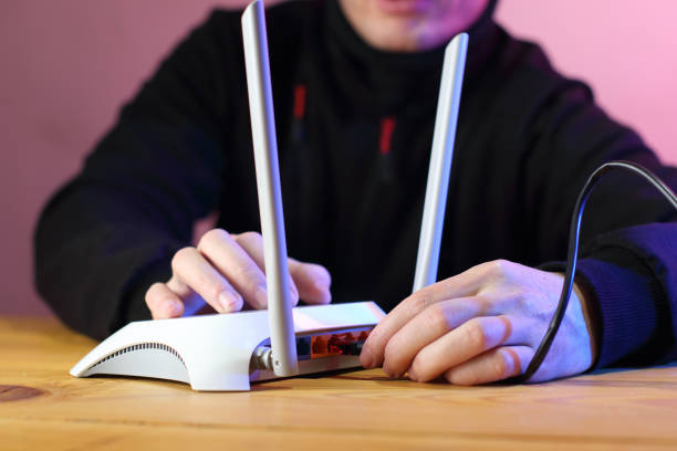 istock connecting internet cable to router with antennas on table 1453309278