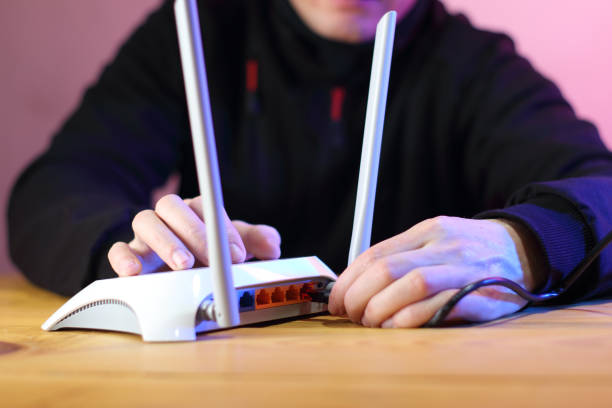 istock connecting internet cable to router with antennas on table 1453309281
