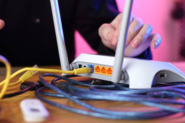 istock router with cable connected backwards ports on person 1453309412
