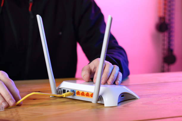 istock router with cable connected backwards ports on person 1453309416