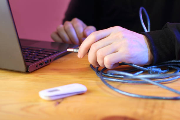 istock connecting a blue usb cable to a laptop on a table by a person 1453309768