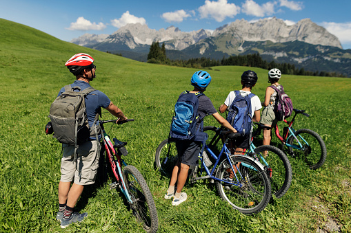 Mother, father and two teenage kids are enjoying a bike trip together in Austrian mountains.\nCanon R5