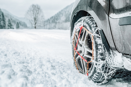 Snow chains on tire of car. Detail of wheel on winter roadthe chains snow for a wheel car on  road in snowy country