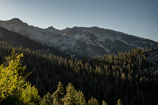 Sunrise with clouds over the Minaret Range of the Sierra Navada Mountains and a small stream flowing down the foreground. Ansel Adams Wilderness Area, California.