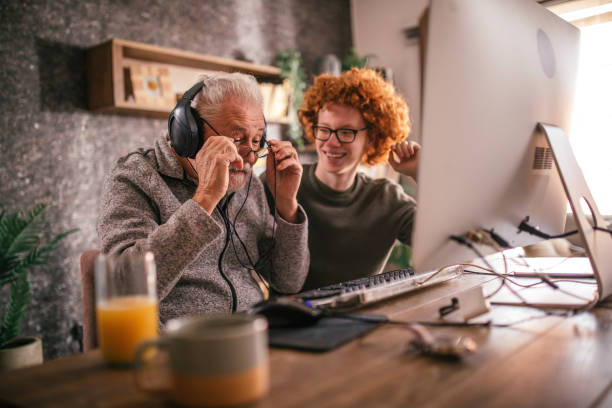 istock grandfather and grandson sitting around table at home and using computer 1453311161