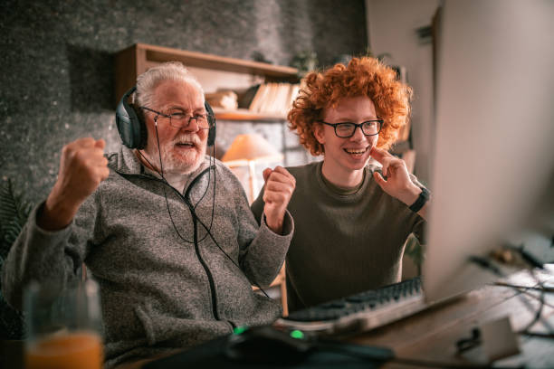 istock grandfather and grandson sitting around table at home and using computer 1453311184
