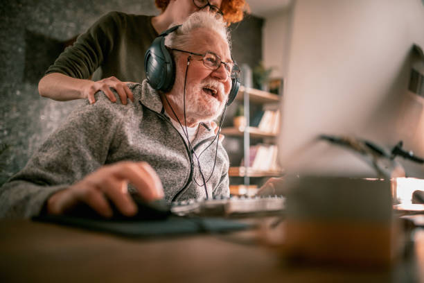 istock grandfather and grandson sitting around table at home and using computer 1453311237