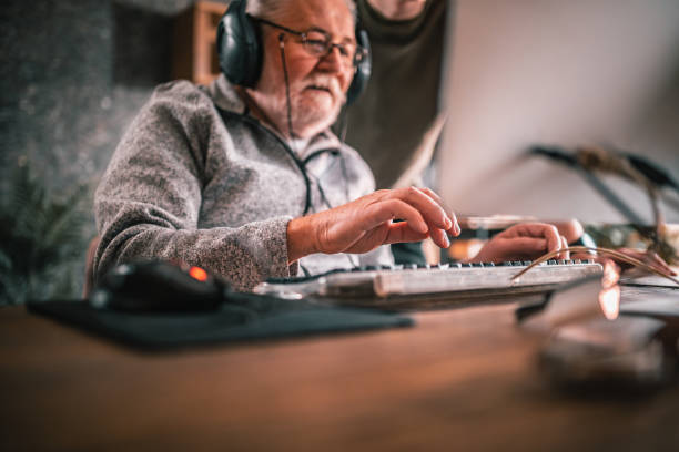 istock grandfather and grandson sitting around table at home and using computer 1453311238