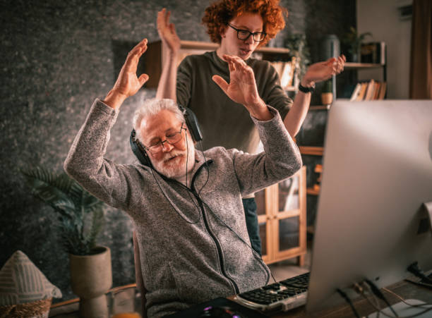 istock grandfather and grandson sitting around table at home and using computer 1453311249