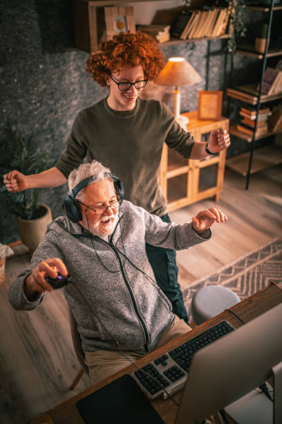 istock grandfather and grandson sitting around table at home and using computer 1453311292