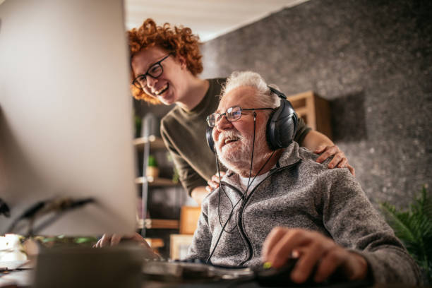 istock grandfather and grandson sitting around table at home and using computer 1453311331