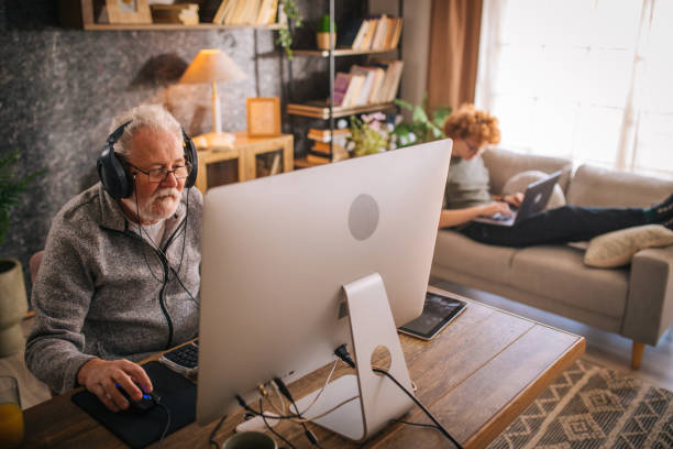 istock grandfather and grandson sitting around table at home and using computer 1453311333