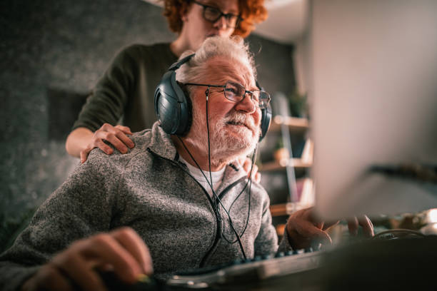 istock grandfather and grandson sitting around table at home and using computer 1453311341